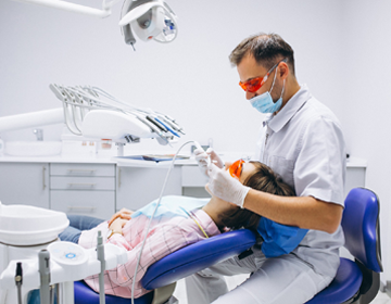 Badanie stomatologiczne pacjentki w gabinecie dentystycznym.